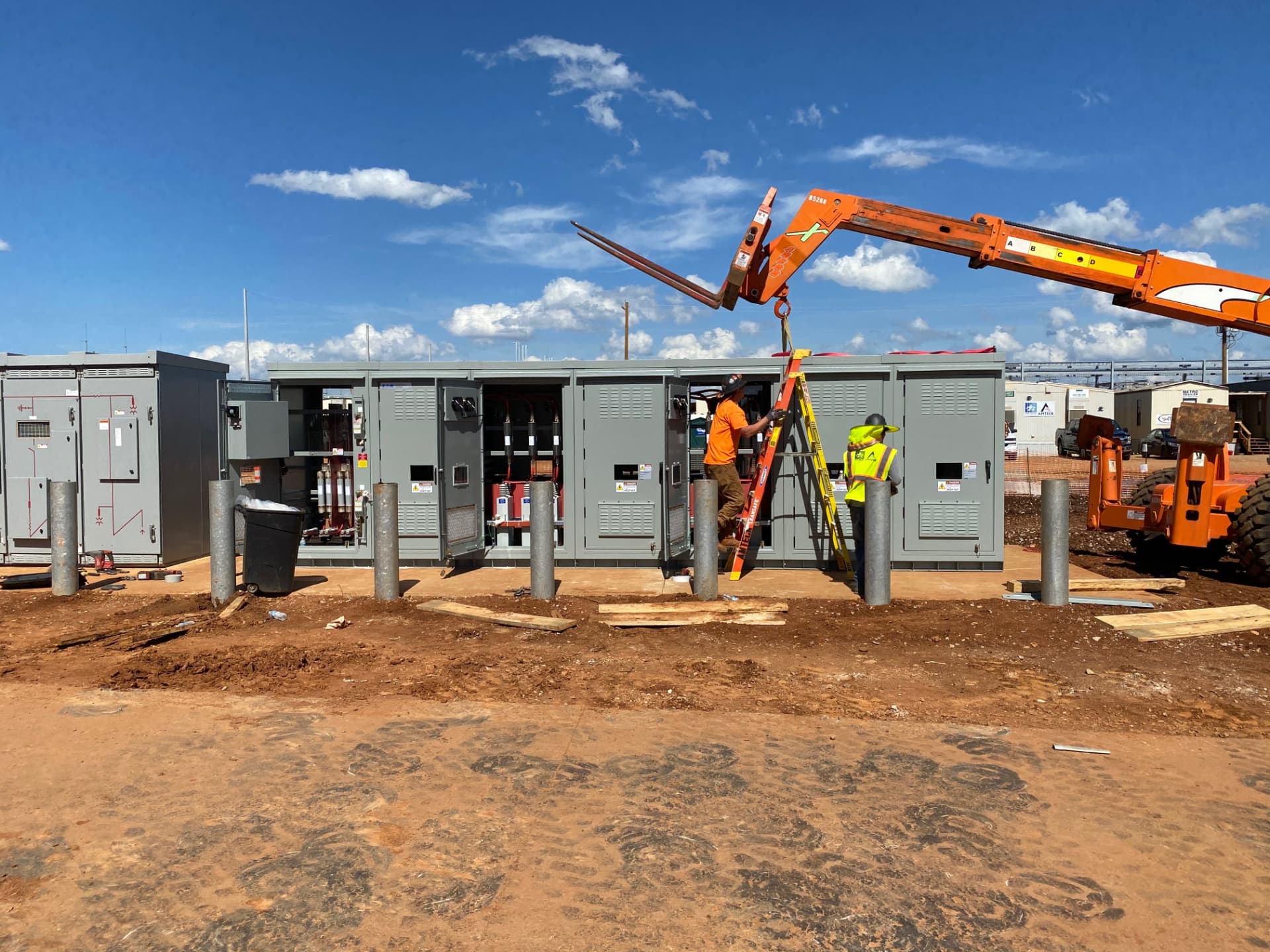 Crews installing exterior medium-voltage switchgear